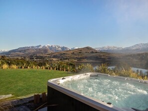 A hot tub with a view of mountains and a lake. - Noa By The Lake | 5 bedrooms, lake view, spa pool, outdoor fireplace (Lake Hayes Estate)