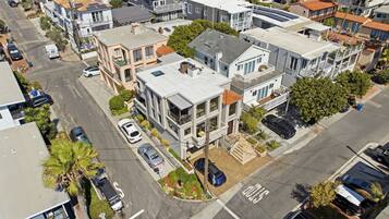 A residential area with multi-story buildings, a street with parked cars, and a clear sky.