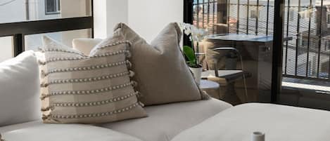 A modern living room with a large window, a sofa, and a coffee table with decorative items.