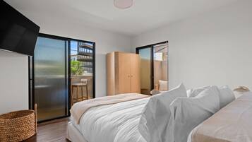 A modern bedroom with a bed, a wardrobe, and a balcony with a view.