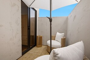 A compact bathroom with a shower, a wicker chair, and a ceiling fan. - Luxury Designer Home | 2 King Ensuites, Sauna (Manhattan Beach)