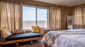 A room with a bed, a window with curtains, a sofa with cushions, and a mirror. - Sunset at Nirvana by Avantstay Pool + Hot Tub + Games Paso Robles Wine Country (San Miguel)