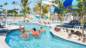 A swimming pool with lounge chairs and palm trees. - South Seas Resort | 1BR Villa Near Captiva Landing (Captiva)