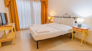A hotel room with a bed, bedside tables, a desk, and a lamp. - 02 Relais du Lac Village - Italian Homing (Desenzano del Garda)