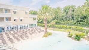 A hotel with a pool area, sun loungers, and a palm tree. - 222 Relais du Lac Village - Italian Homing (Desenzano del Garda)