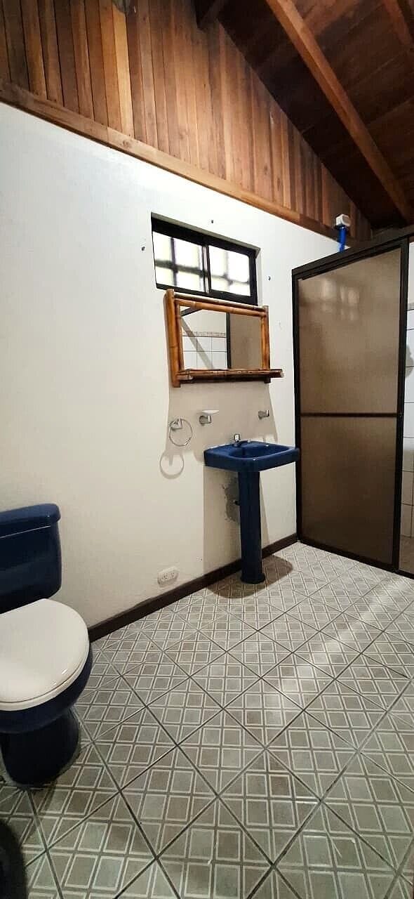 Un baño con inodoro, lavamanos y espejo.