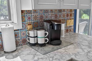 A kitchen with a marble countertop, a coffee maker, a kettle, and a paper towel holder. - Cozy 2BD 2BA Hideaway w/ Pond Views & Firepit (East Stroudsburg)