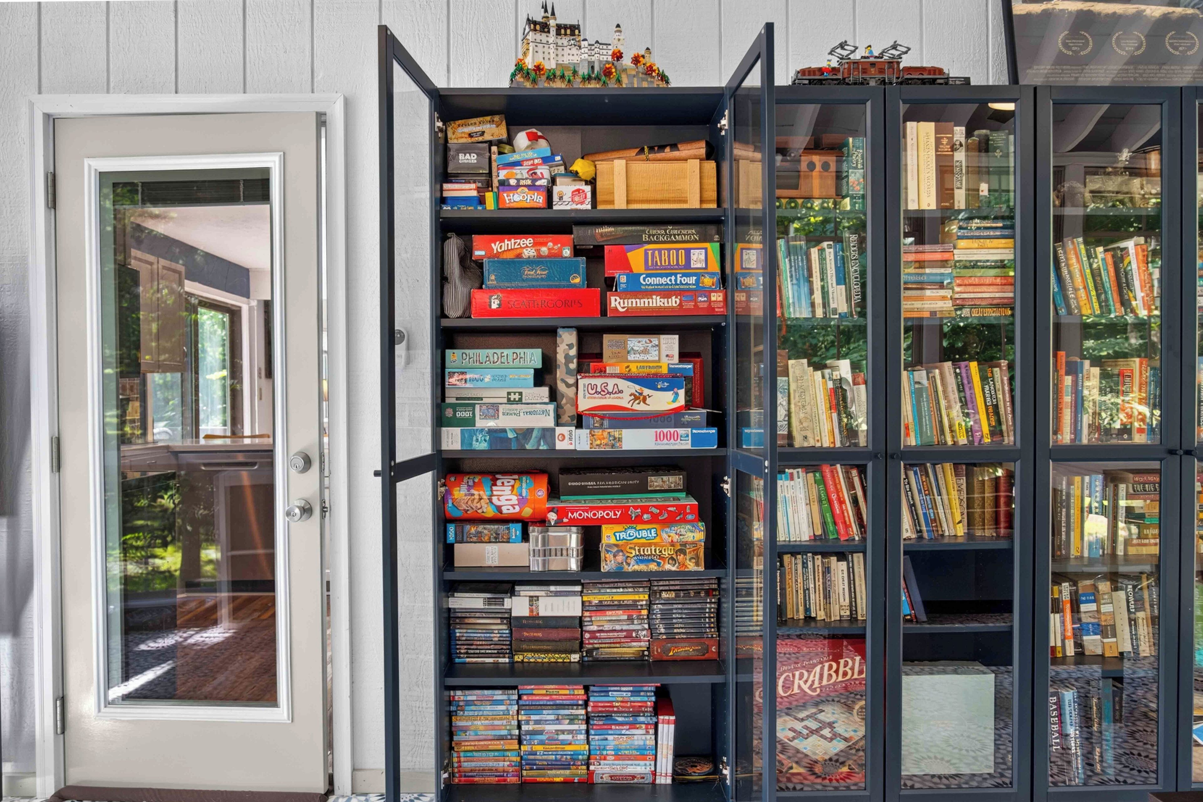 A bookshelf with various board games and a collection of books.