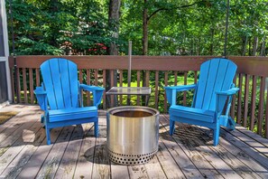 A wooden deck with two blue Adirondack chairs and a metal stove. - Cozy 2BD 2BA Hideaway w/ Pond Views & Firepit (East Stroudsburg)