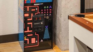A retro arcade machine with a neon sign, placed against a textured wall. - Shady Ridge - Hot Tub~Game Room~Star Gazing Dome (Mineral Bluff)