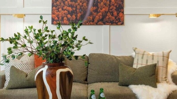 A living room with a sofa, a coffee table with a fruit platter, a vase with green foliage, and a painting of a winding road through autumn foliage. - Shady Ridge - Hot Tub~Game Room~Star Gazing Dome (Mineral Bluff)