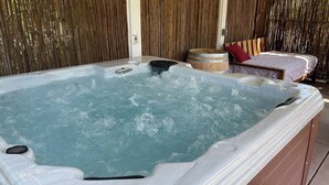 Ein Whirlpool mit Holzrahmen und einer Holzverkleidung im Hintergrund.