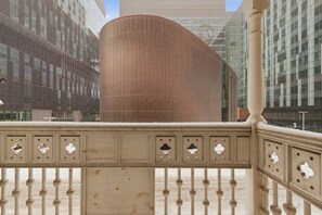 A modern building with a curved facade, a decorative metal fence with cut-out patterns, and a clear sky. - Modern 1BR • Walk to Old Port (Montreal)
