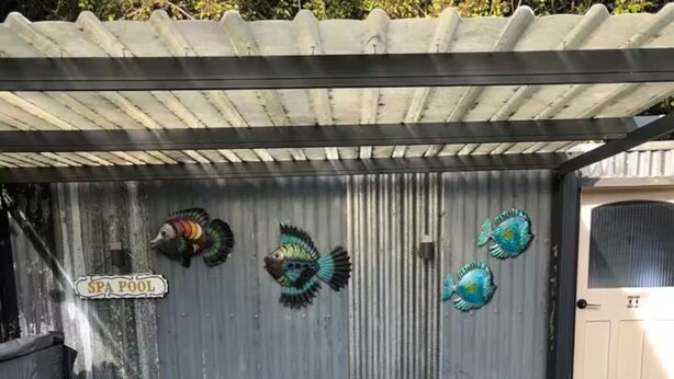Ein Wellnessbereich mit Whirlpool, umgeben von Fisch-Wandbildern und einer Holzterrasse.