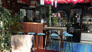 Eine Bar mit einer Theke, Hockstühlen und einem gemusterten Teppich.
