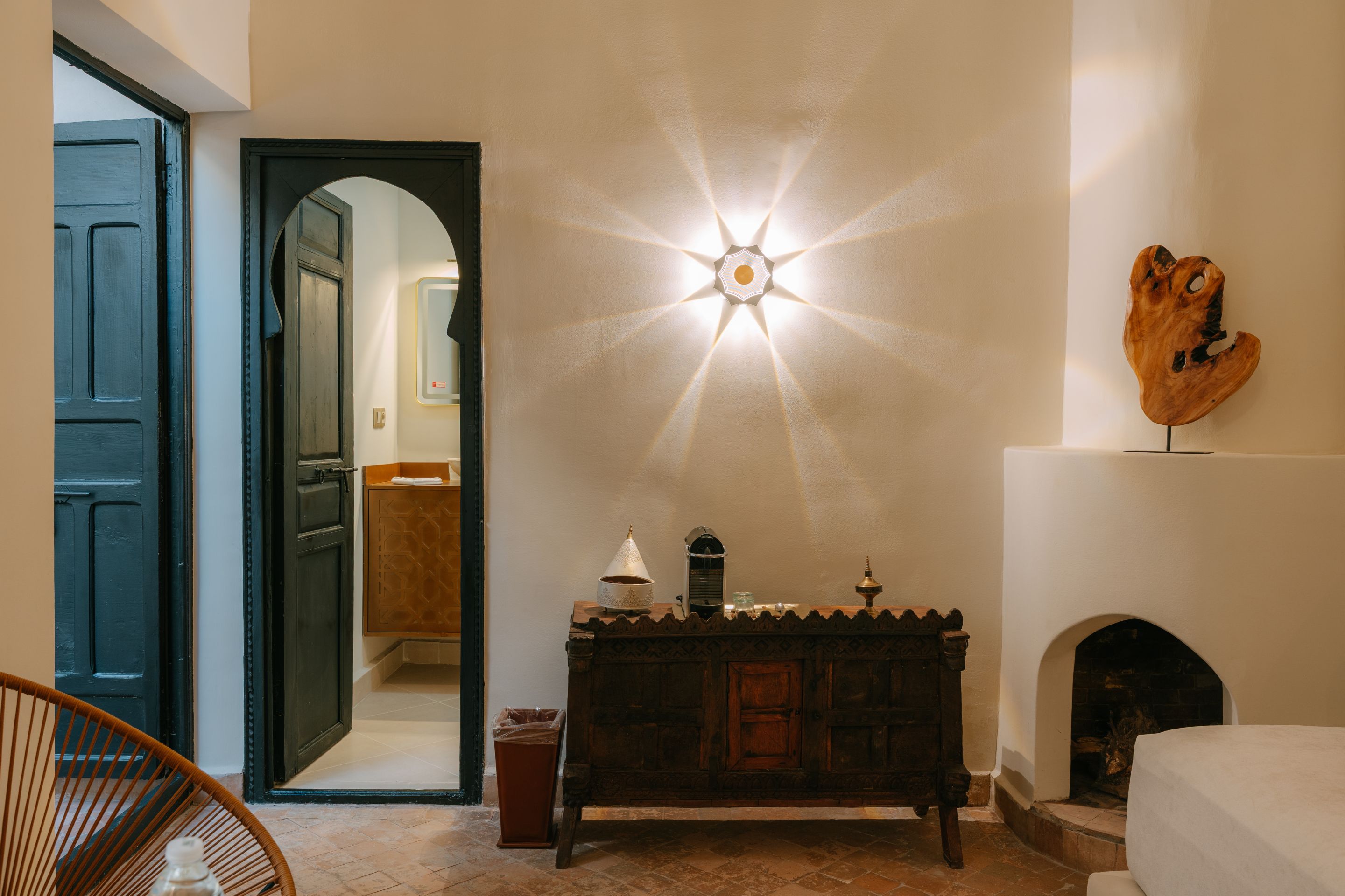 Una habitació amb un armari de fusta, una làmpada penjada a la paret i una llar de foc.