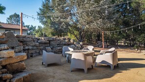 Eine Terrasse im Freien mit Steinmauern, einem Tisch und vier Stühlen.