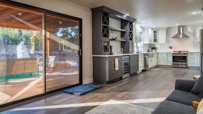 A modern kitchen with a sliding glass door leading to a patio area. - Na Hoku Ranch by Avantstay Spanish Hacienda + Spa + Court 5.5 Acres Near Paso (Atascadero)