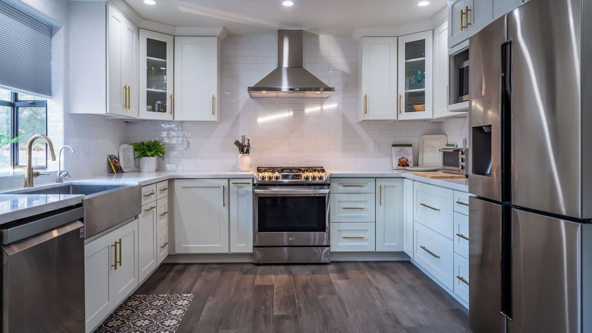 A modern kitchen with white cabinetry, stainless steel appliances, and a central island.
