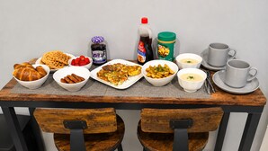 A dining table with various food items and condiments, accompanied by two chairs and a set of white cups and saucers. - Maple Haven | Spacious 3BR Private Luxury Suite • Huge Yard • Sleeps 6 (Pickering)
