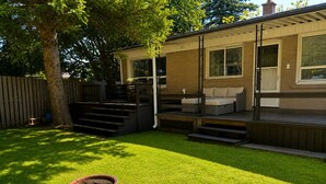 A backyard with a patio, outdoor seating, a fire pit, and a wooden fence. - Maple Haven | Spacious 3BR Private Luxury Suite • Huge Yard • Sleeps 6 (Pickering)