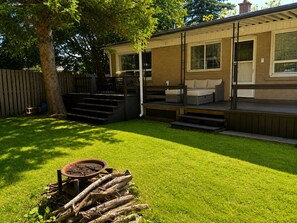A backyard with a patio, outdoor seating, a fire pit, and a wooden fence. - Maple Haven | Spacious 3BR Private Luxury Suite • Huge Yard • Sleeps 6 (Pickering)