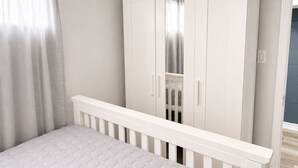 A bedroom with a white crib, a wardrobe, and a window with curtains. - Maple Haven | Spacious 3BR Private Luxury Suite • Huge Yard • Sleeps 6 (Pickering)