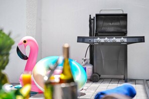 Ein Grill mit Bedienfeld, eine Flamingo-Dekoration und ein farbenfroher Ballon.