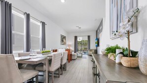 Uma sala de jantar moderna com uma mesa comprida, cadeiras e vista para o espaço exterior.