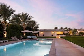 A pool area with lounge chairs and umbrellas, a house with a tiled roof, and palm trees. - Desert Ranch Retreat, Luxury Stay, Weddings & Special Events (Indio)