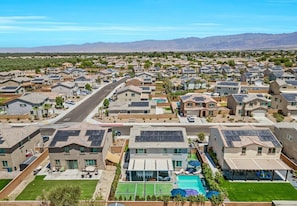 A residential area with houses, solar panels, and a clear sky. - 8BR Luxury Pool Spa Pickleball Hoops Game Room BBQ - Sleeps 28 (Coachella)