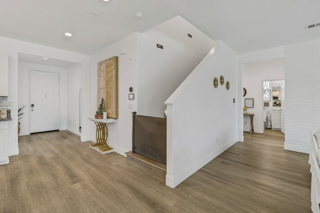 A spacious interior with a staircase leading to a loft area, a fireplace, and a kitchen visible in the background.