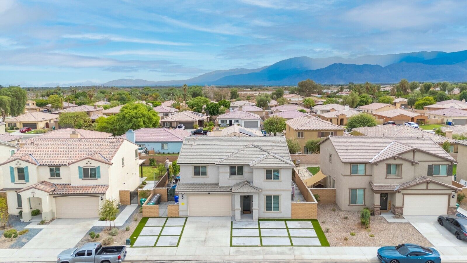 Um bairro residencial com casas de telhado apaleinado e vista clara para montanhas ao fundo.