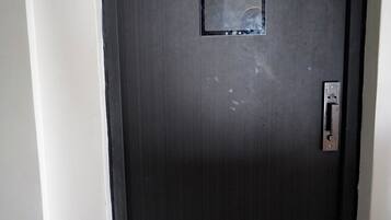A dark-colored door with a rectangular window and a door handle.