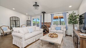 A living room with two white sofas, a wooden coffee table, a fireplace, and a large mirror. - Casa Robles by Avantstay Spa + Firepit + BBQ Rural Eastside Paso Robles (Paso Robles)