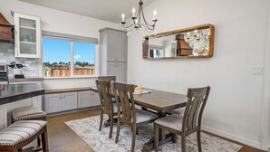 A kitchen with a dining area, a chandelier, and a large window. - Casa Robles by Avantstay Spa + Firepit + BBQ Rural Eastside Paso Robles (Paso Robles)