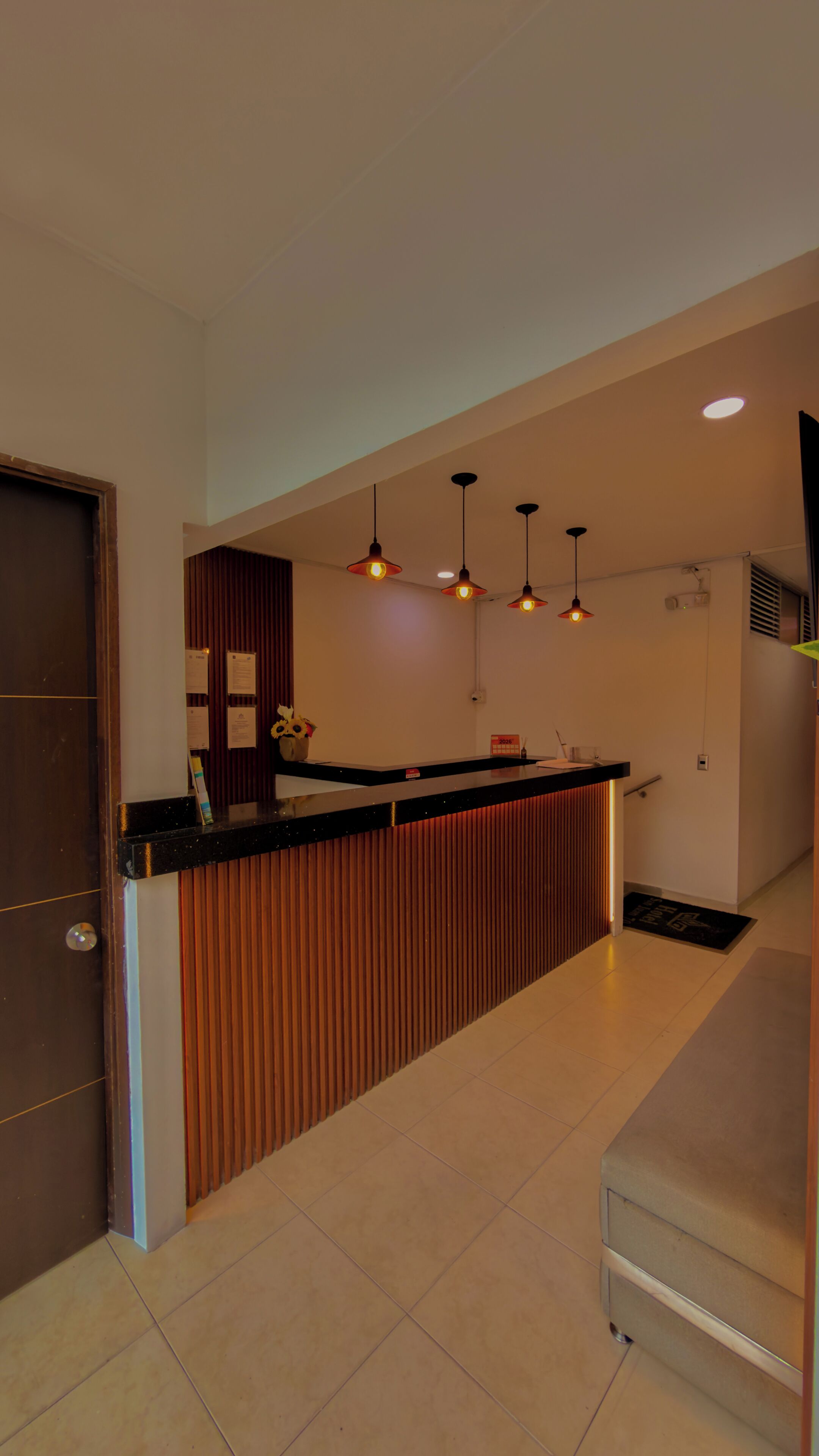 Une cuisine moderne avec un plan de travail en bois, des luminaires suspendus et un sol carrelé.