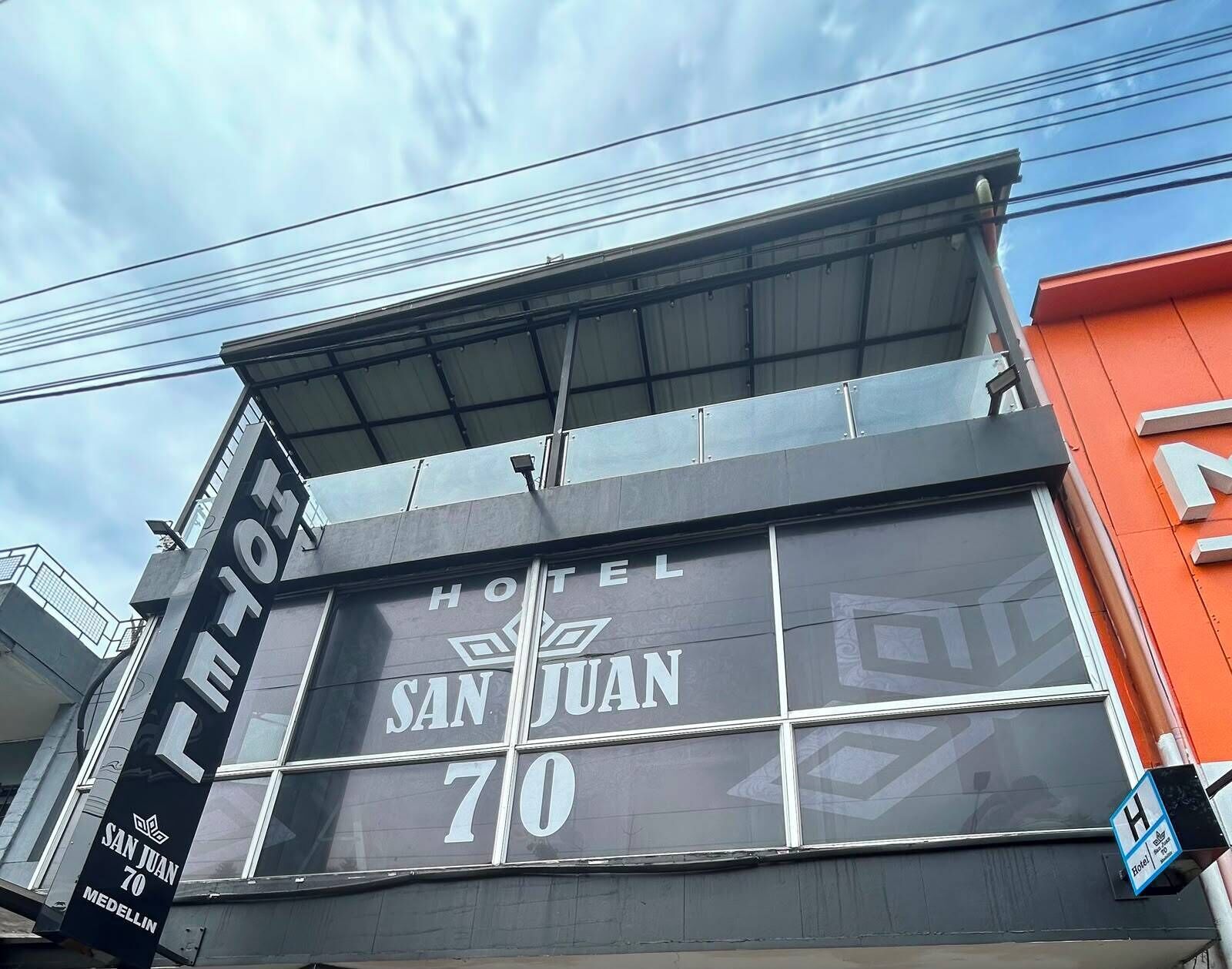 Letrero de hotel que indica 'HOTEL SAN JUAN 70', nombre y dirección.