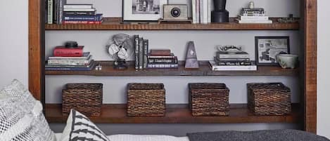 Una estantería con libros, una cámara antigua y objetos decorativos.