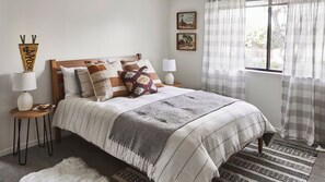 A neatly arranged bedroom with a bed, two bedside tables, a lamp, and a window with curtains. - Olive & Stone by Avantstay Private Acre + Hillside Views + Firepit Paso Robles (Templeton)