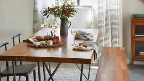 A dining table set with plates of food, glasses of wine, and a vase with flowers. - Olive & Stone by Avantstay Private Acre + Hillside Views + Firepit Paso Robles (Templeton)