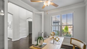 A dining area with a wooden table, chairs, a globe, and a vase with greenery. - Luxury League City Retreat (League City)