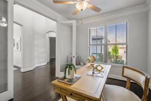 A dining area with a wooden table, chairs, a globe, and a vase with greenery. - Luxury League City Retreat (League City)