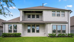 A two-story house with a balcony, large windows, and a well-maintained lawn. - Luxury League City Retreat (League City)