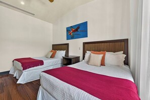 Ett hotellrum med två sängar, en inredning i rött och vitt, och en tavla på väggen.