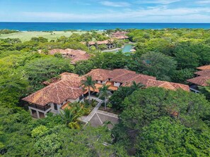 A resort with multiple buildings, a golf course, and a view of the ocean. - Tropical Villa In Hacienda Pinilla (Hacienda Pinilla)