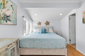 A bedroom with a bed, a dresser, a window with blinds, and wall art. - Old Town Apartment with Parking, Walk to the Beach (Key West)