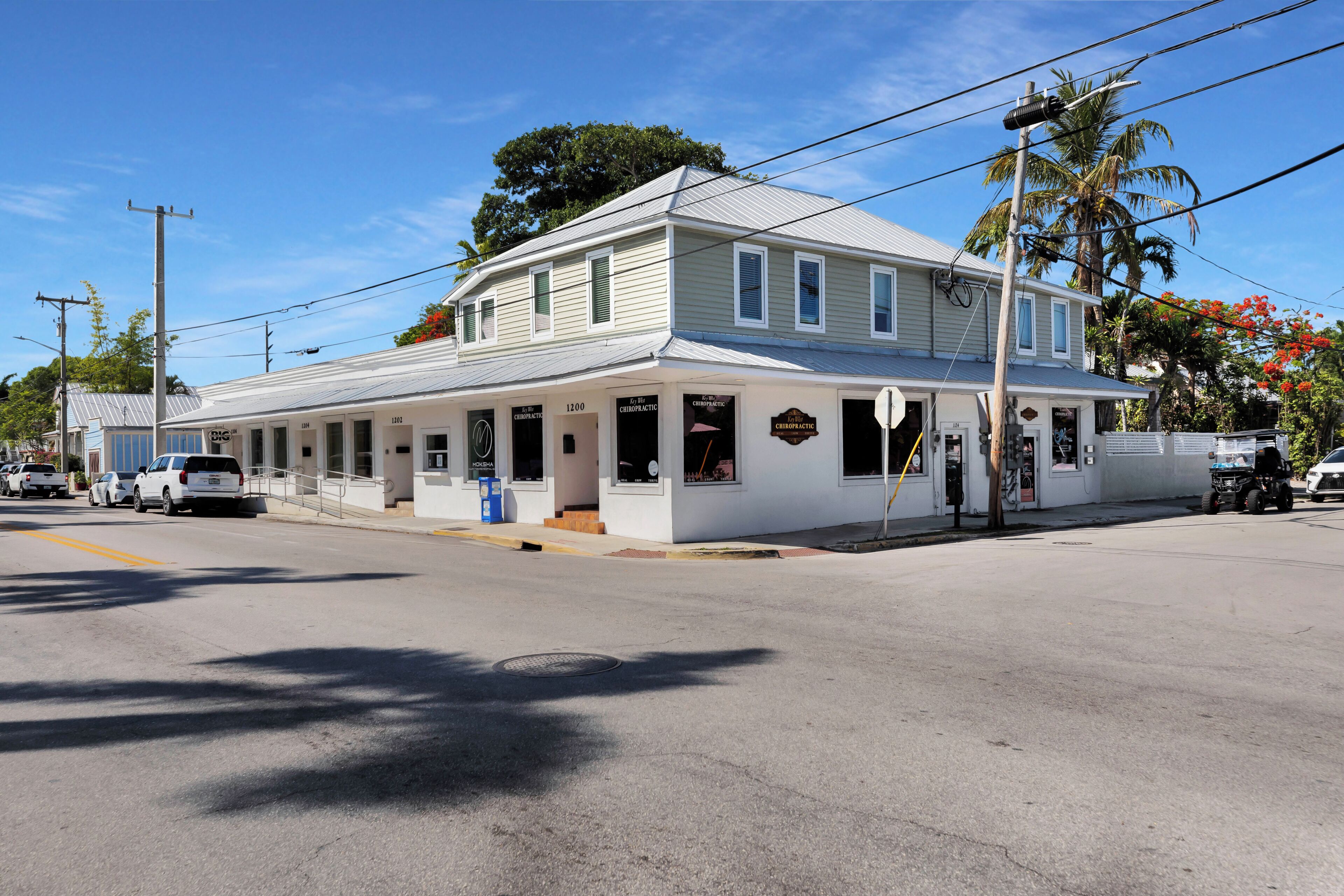 A two-story building with a covered porch and a sign indicating it is a chiropractic clinic.