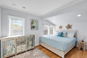 A bedroom with a bed, dresser, and artwork. - Old Town Apartment with Parking, Walk to the Beach (Key West)