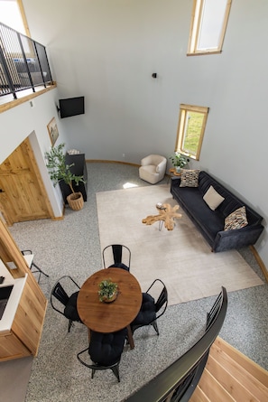 Un intérieur moderne comprenant un coin repas, un ensemble de canapés et un escalier.